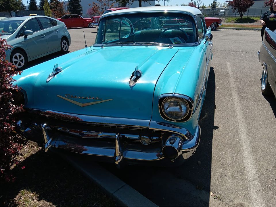A blue car is parked in a parking lot