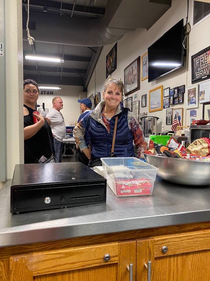 A woman is standing at a counter in a restaurant.