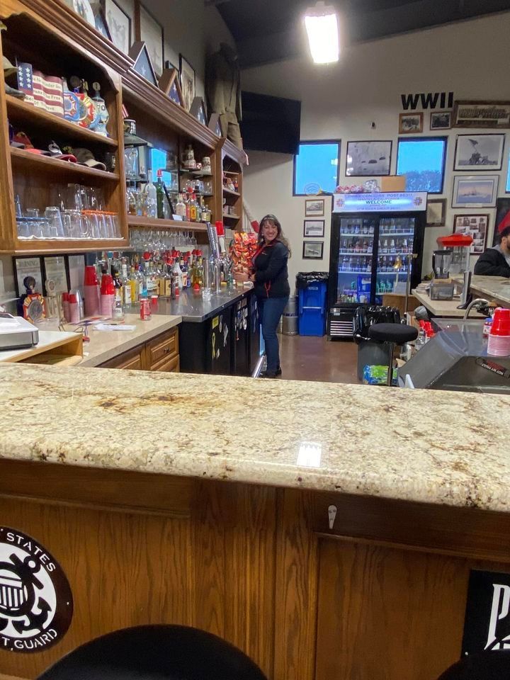 A woman is standing behind a counter in a store.