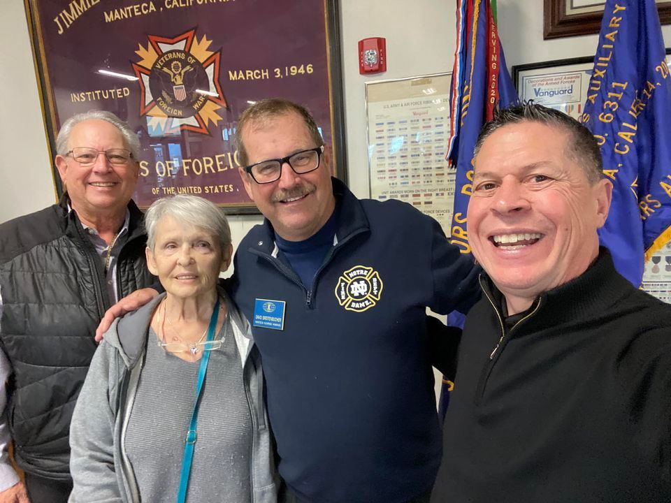 A group of people posing for a picture in front of flags