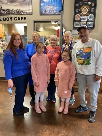 A group of people are posing for a picture in a cafe.