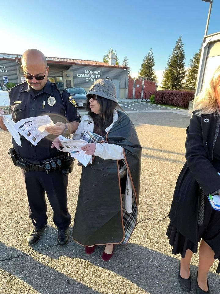 A group of people are standing on the side of the road looking at papers.