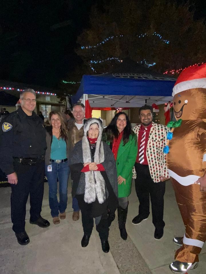 A group of people are posing for a picture with a gingerbread man.