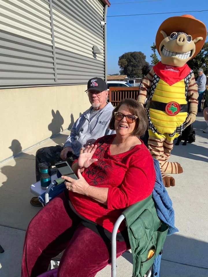 A woman in a wheelchair is sitting next to a man in a cowboy hat.