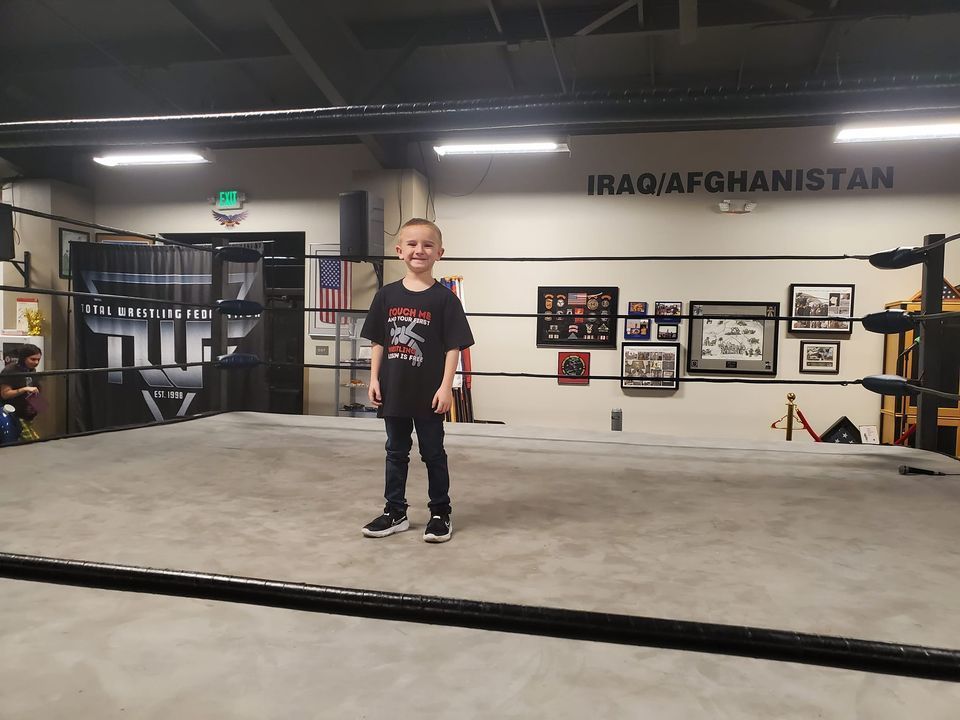 A young boy is standing in a boxing ring in iraq / afghanistan