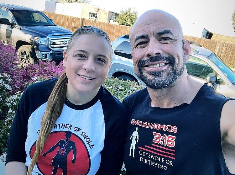 A man and a woman are posing for a picture in front of a truck.