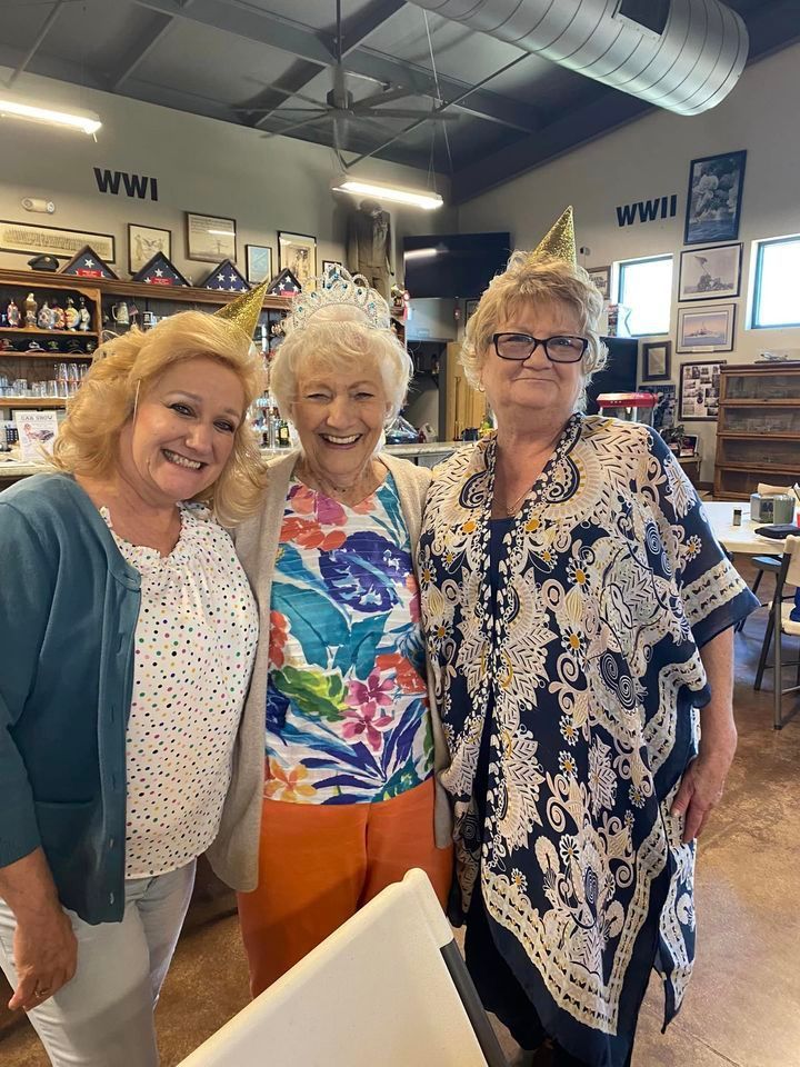 Three women are posing for a picture together in a room.