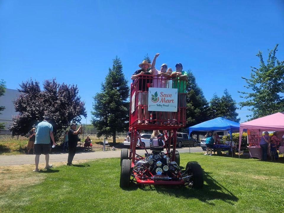 A group of people are riding on a buggy that says save mart