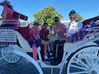 A group of people are riding in a horse drawn carriage.