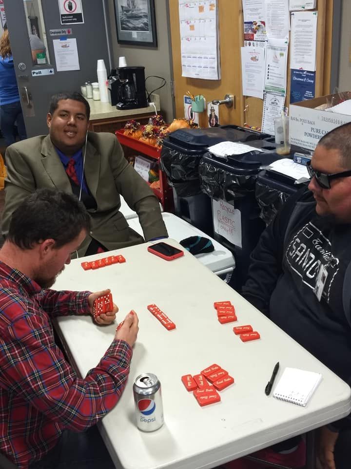 Three men are sitting at a table with a can of pepsi on it