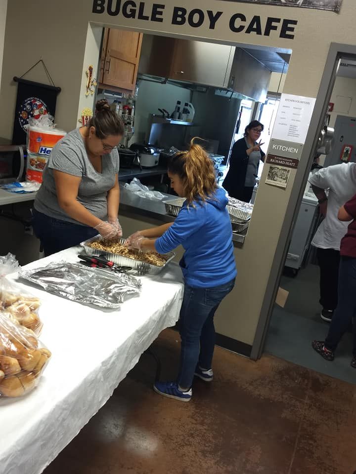 Two women are preparing food in a bugle boy cafe