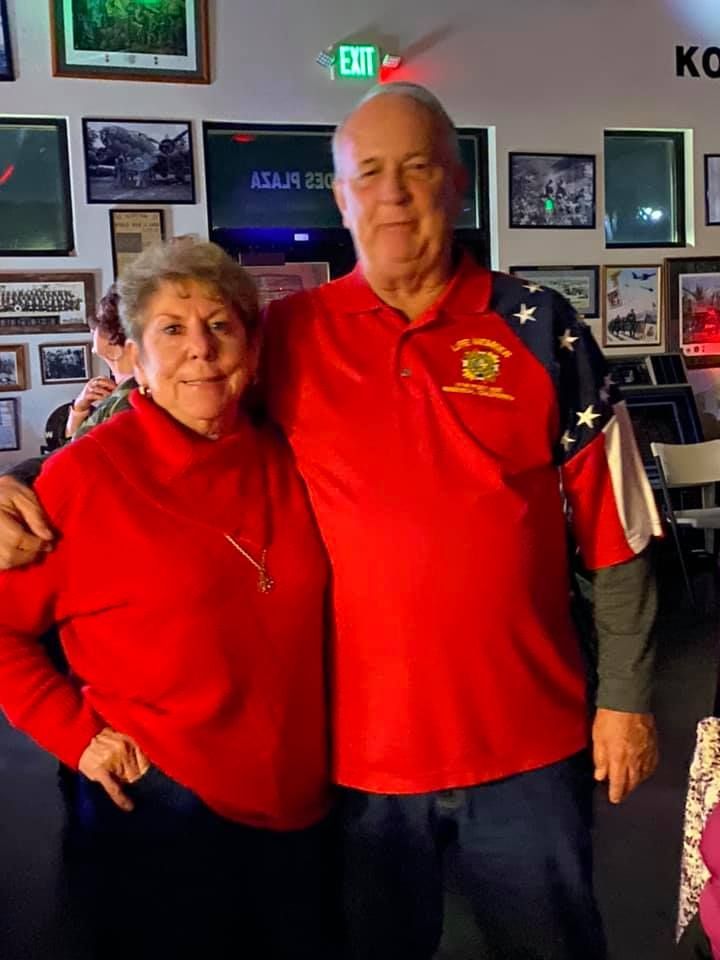 A man and a woman are posing for a picture in a restaurant