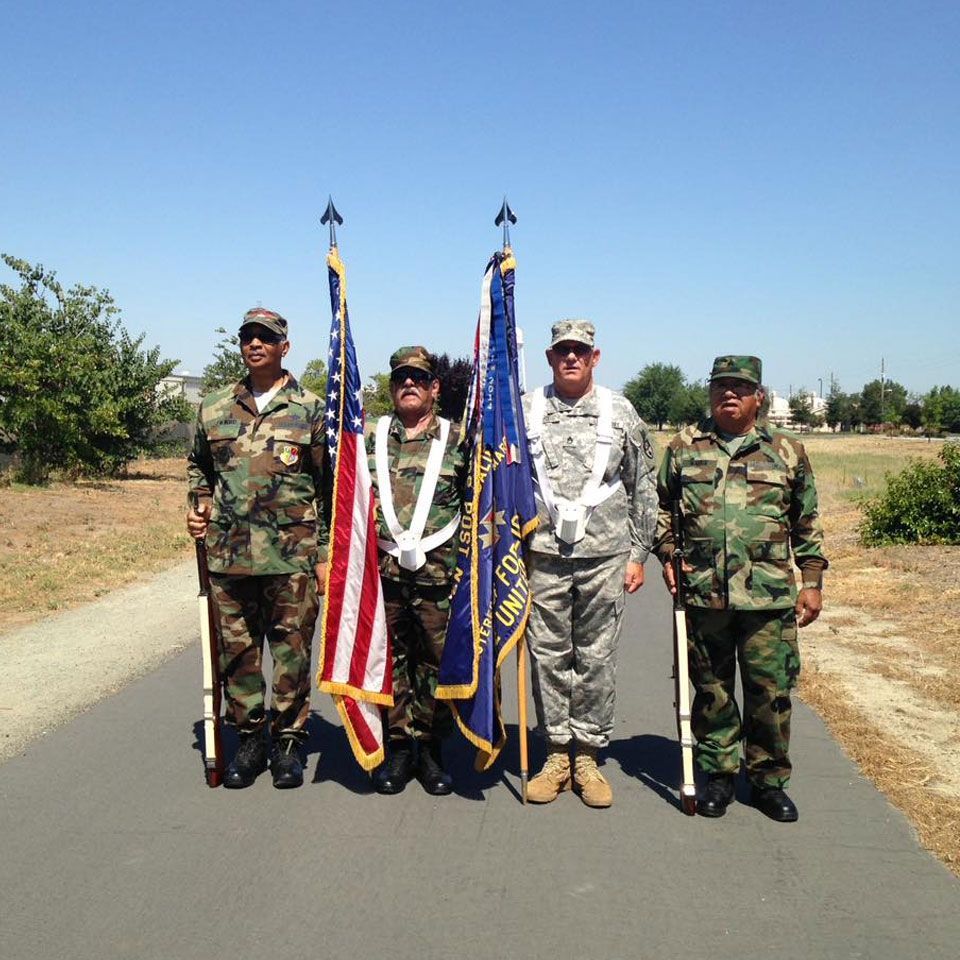 A group of soldiers standing on a road holding flags