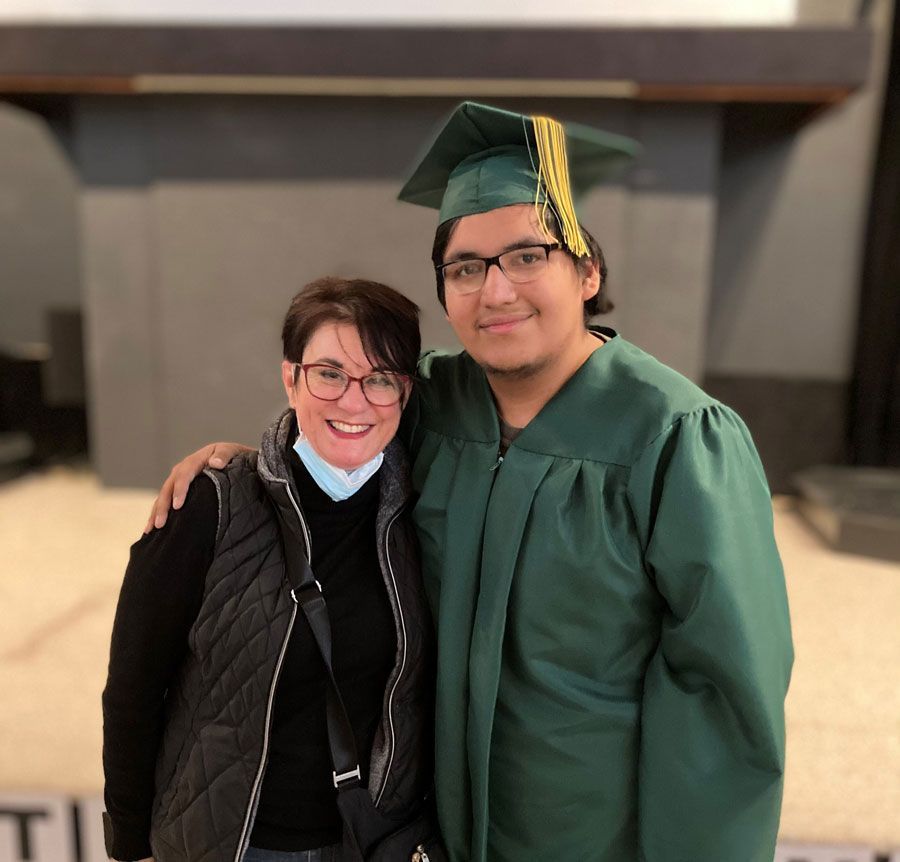 a man in a graduation cap and gown poses with a woman