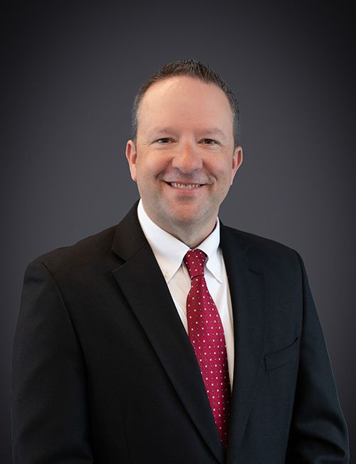 A man in a suit and tie is smiling for the camera