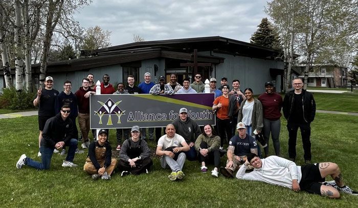 a group of people are posing for a picture in front of a sign .
