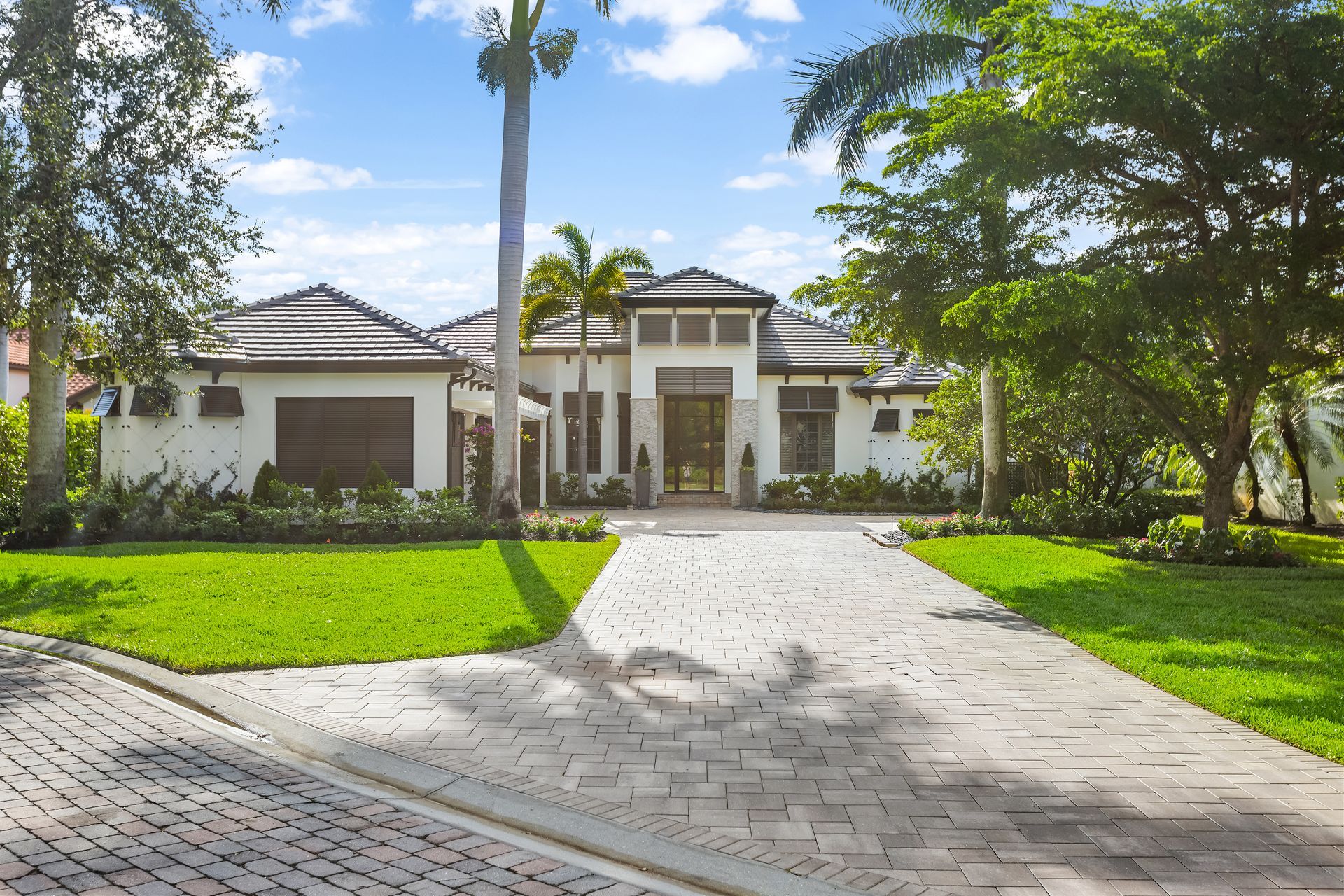 A Large White House with A Palm Tree in Front of It