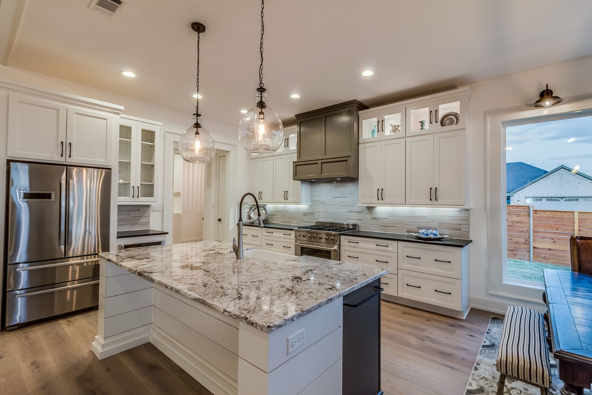 Kitchen remodeling with granite countertop, modern cabinetry, and two pendant lights above island. — Naples, FL — Treeline Building