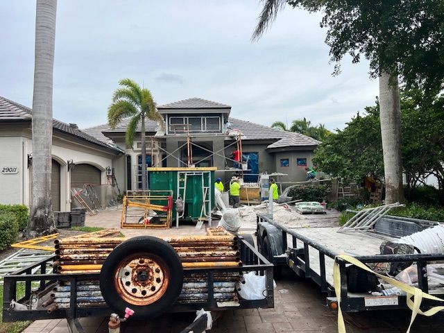 Two Trailers Are Parked in Front of A House Under Construction.