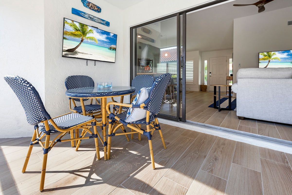 A patio with a table and chairs and a television on the wall.