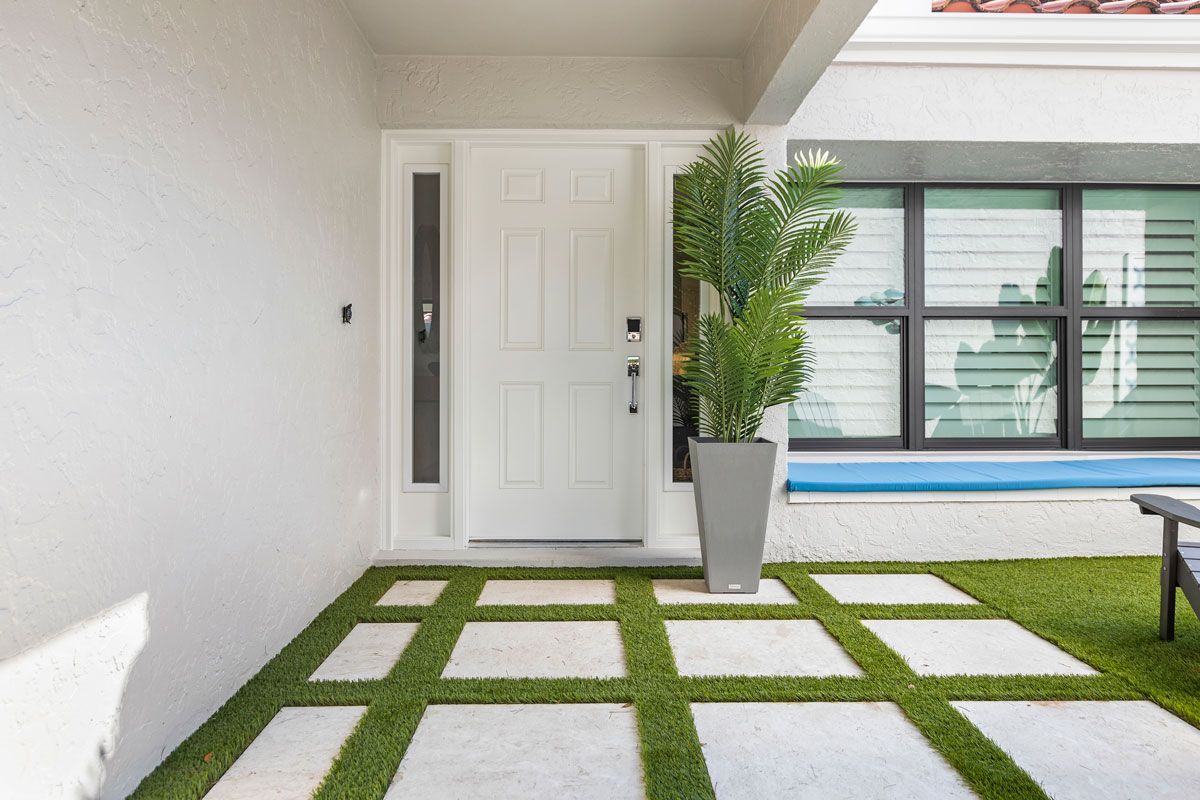 A white door with a potted plant in front of it