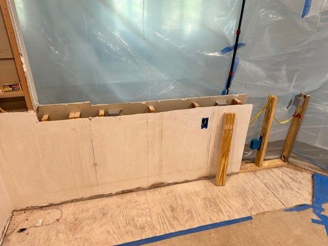 A room is being remodeled and covered in plastic.