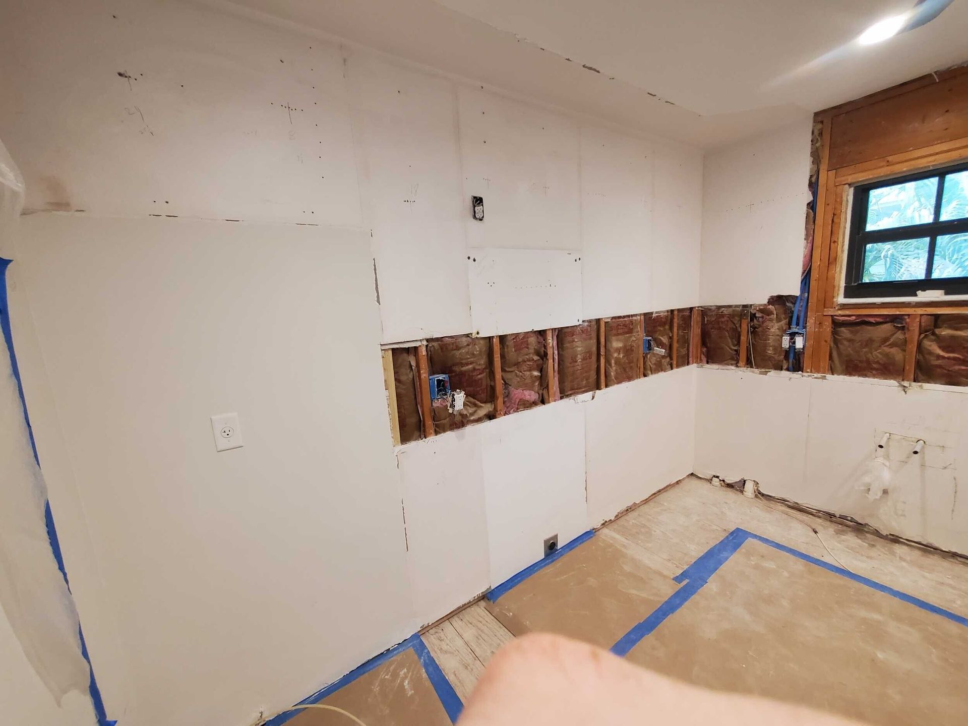 A person is standing in a room that is being remodeled.