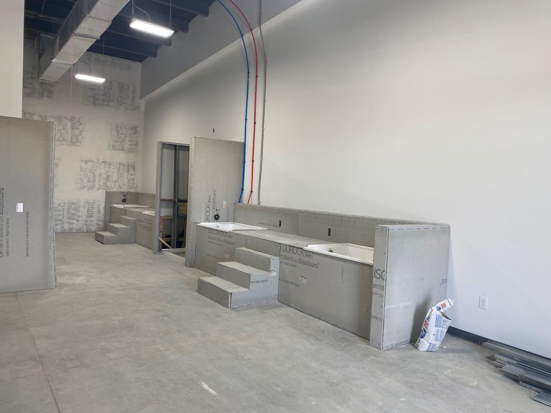 A large empty room with unfinish dog wash table.