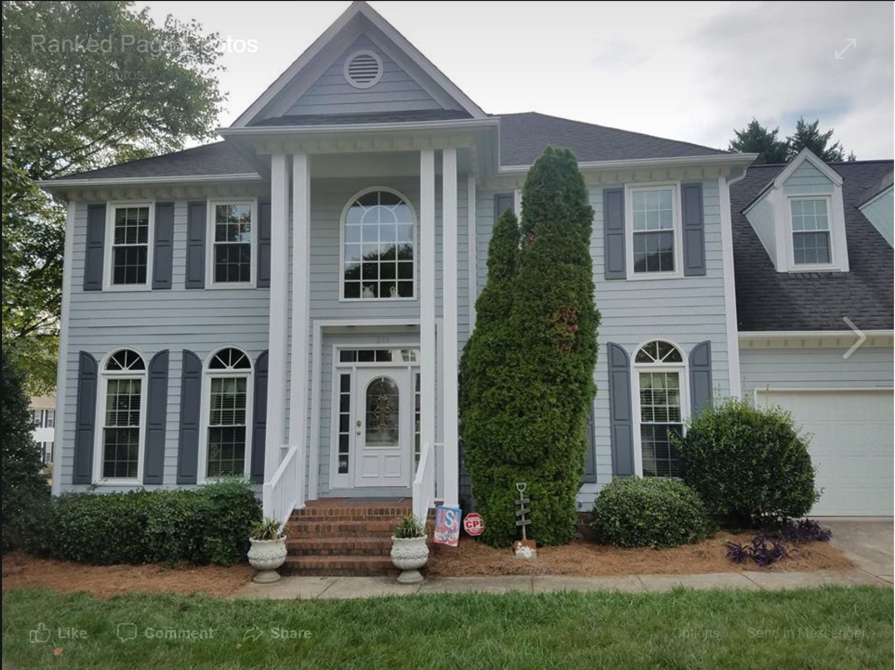 a large white house with a gray roof is for sale