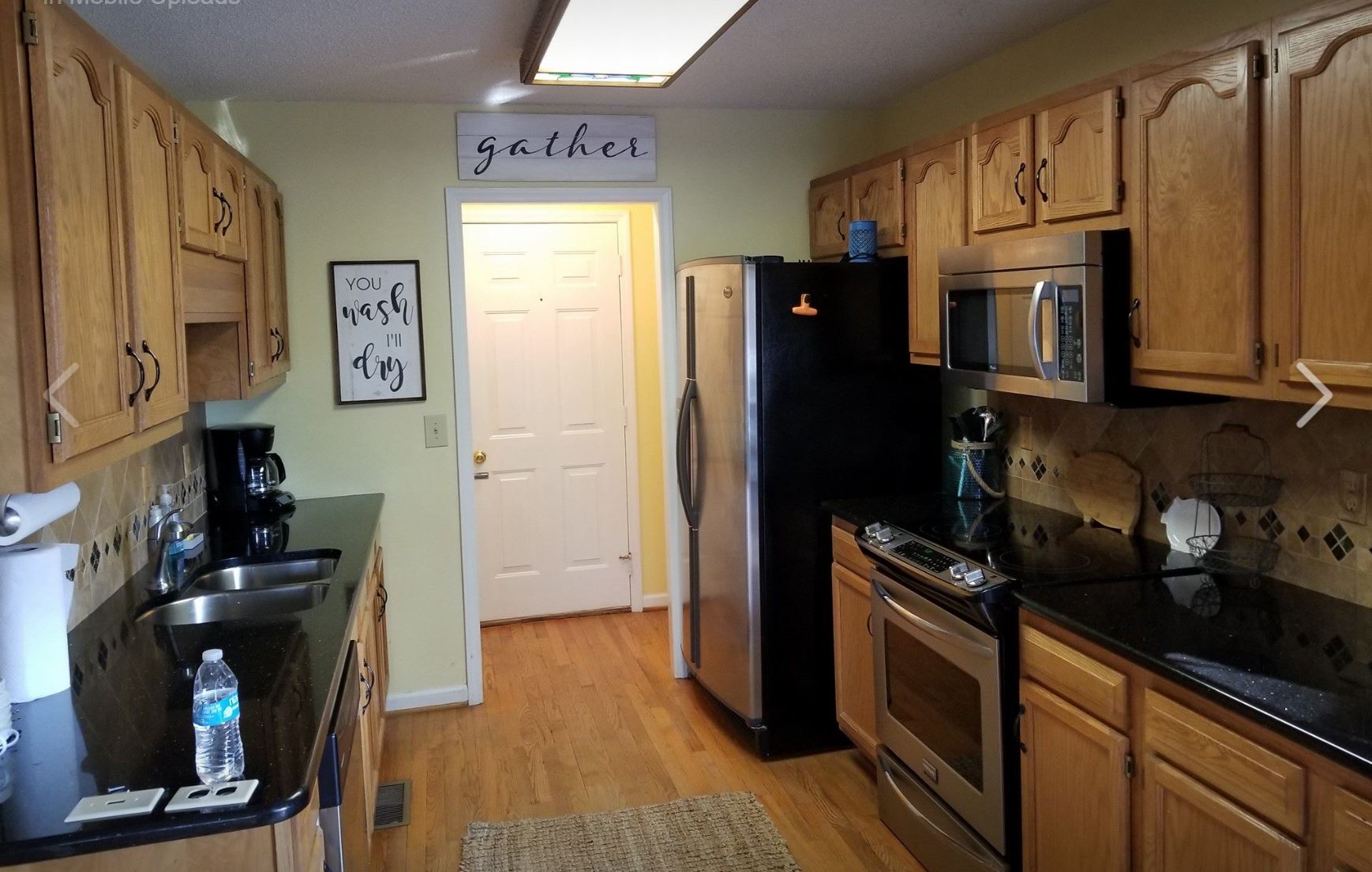 a kitchen with a sign above the refrigerator that says gather