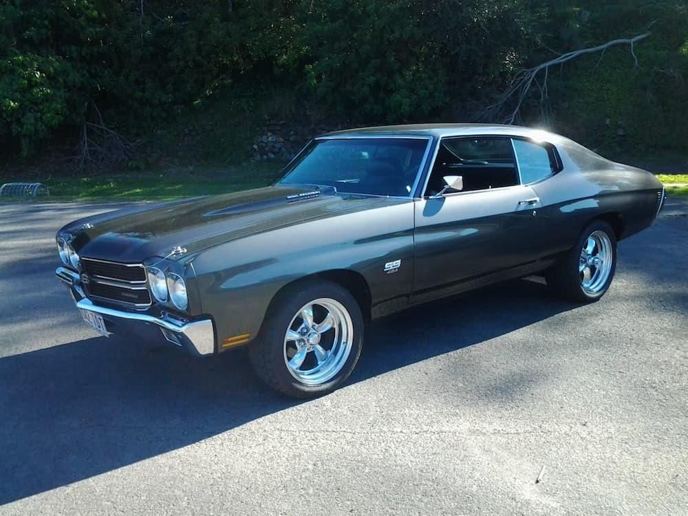 A Black Car Is Parked On The Side Of The Road — Platinum Paint & Panel Southport In Southport, QLD
