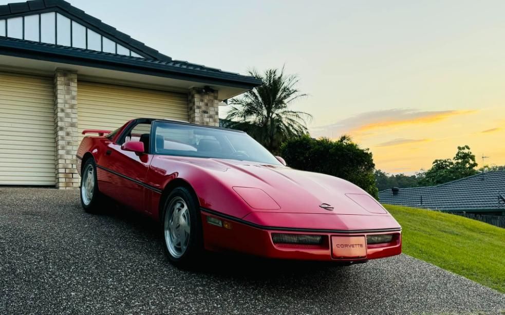 A Red Corvette Convertible Is Parked In Front Of A House — Platinum Paint & Panel Southport In Southport, QLD