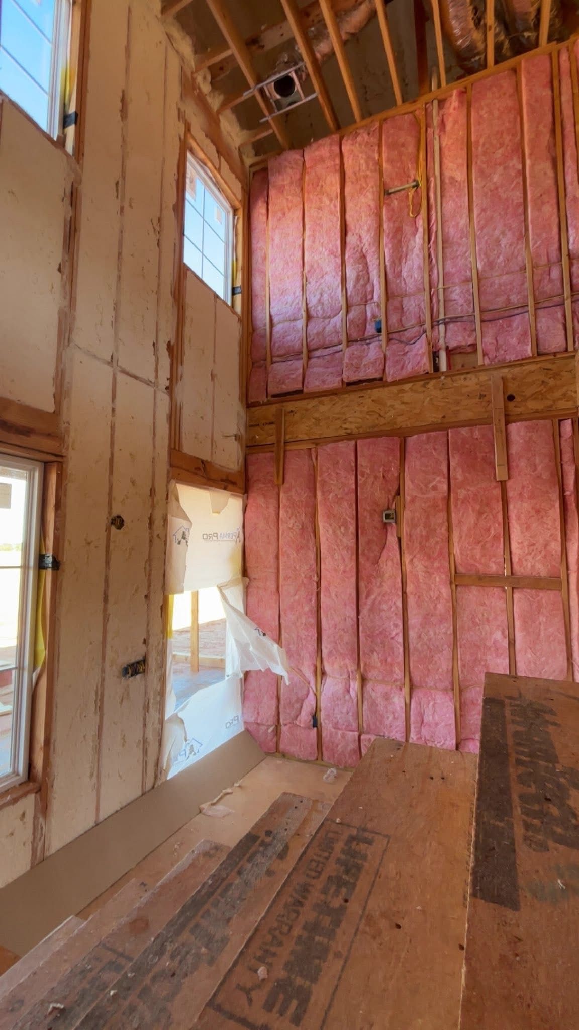 Industrial interior with insulated wall panels and an open doorway to a workshop area