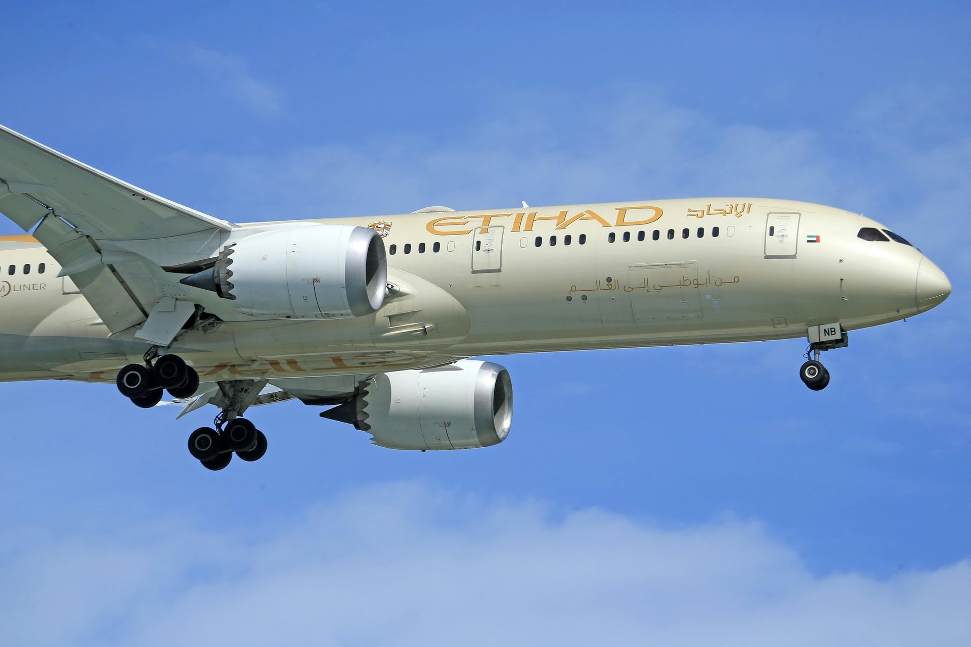 A large passenger jet is flying through a blue sky.