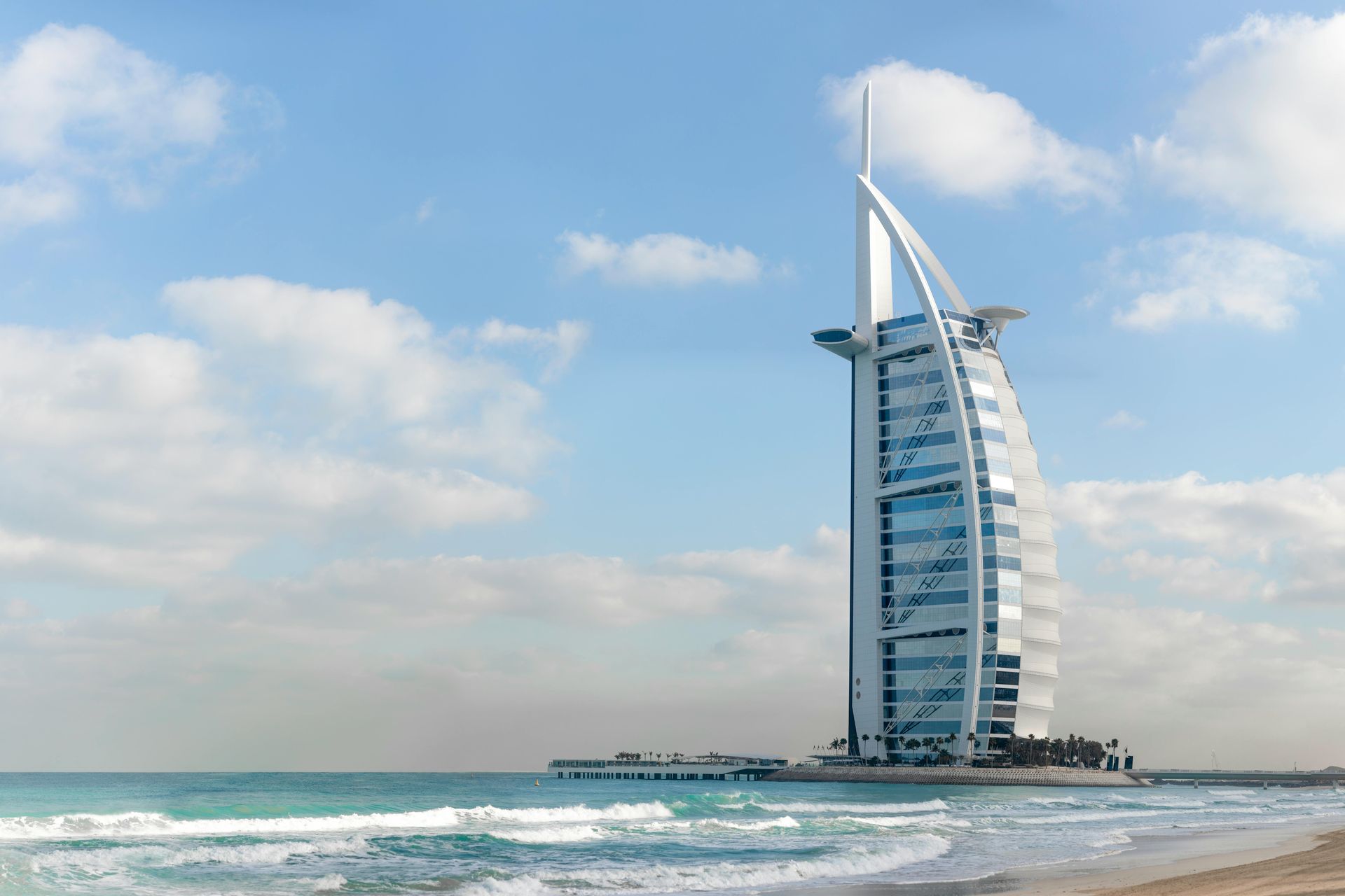 A large building is sitting on top of a sandy beach near the ocean