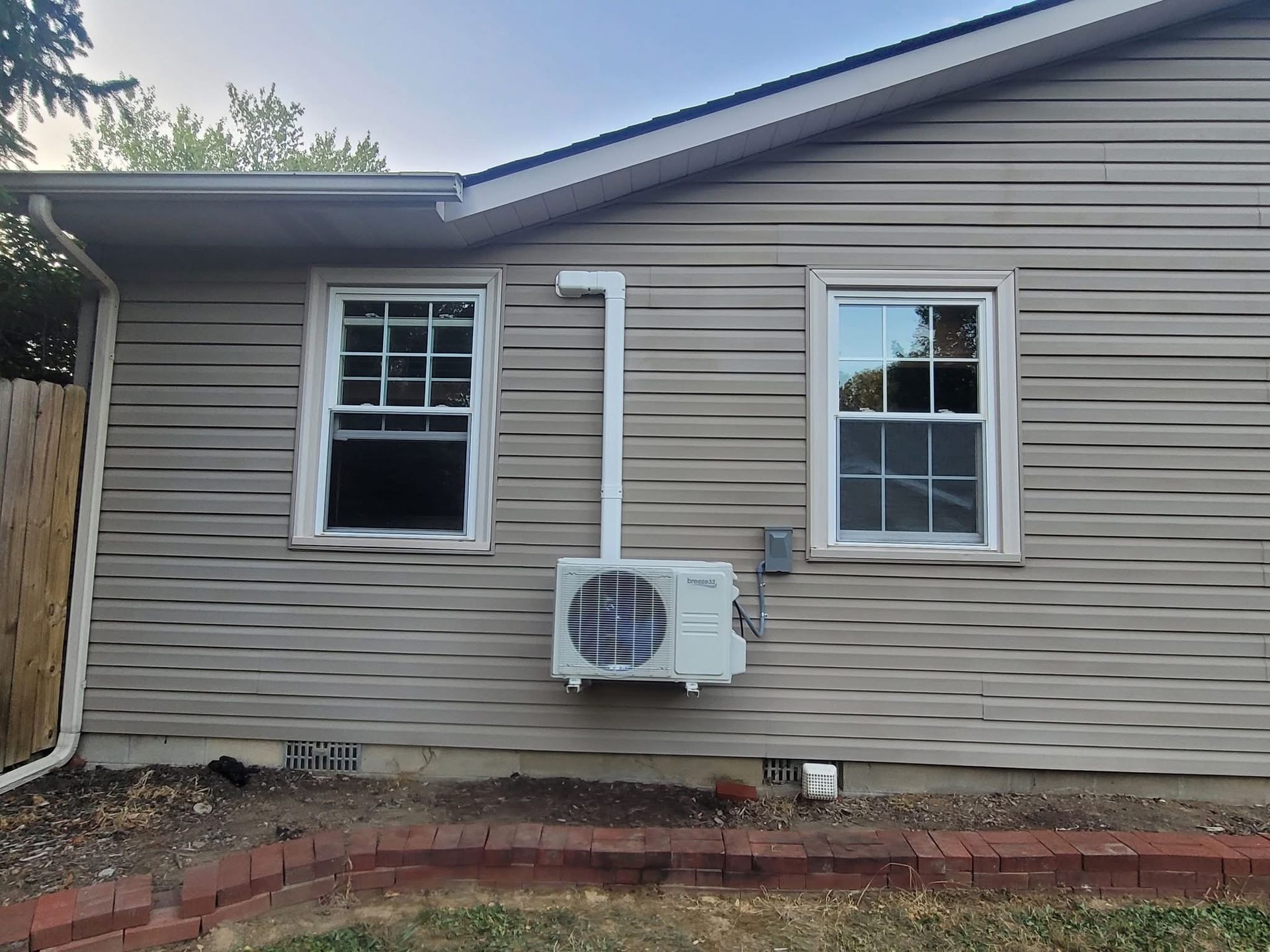 Hands of a repair person working on air conditioning unit using tools.