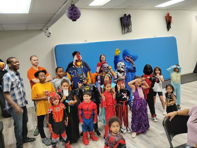 A group of children dressed in halloween costumes are posing for a picture.