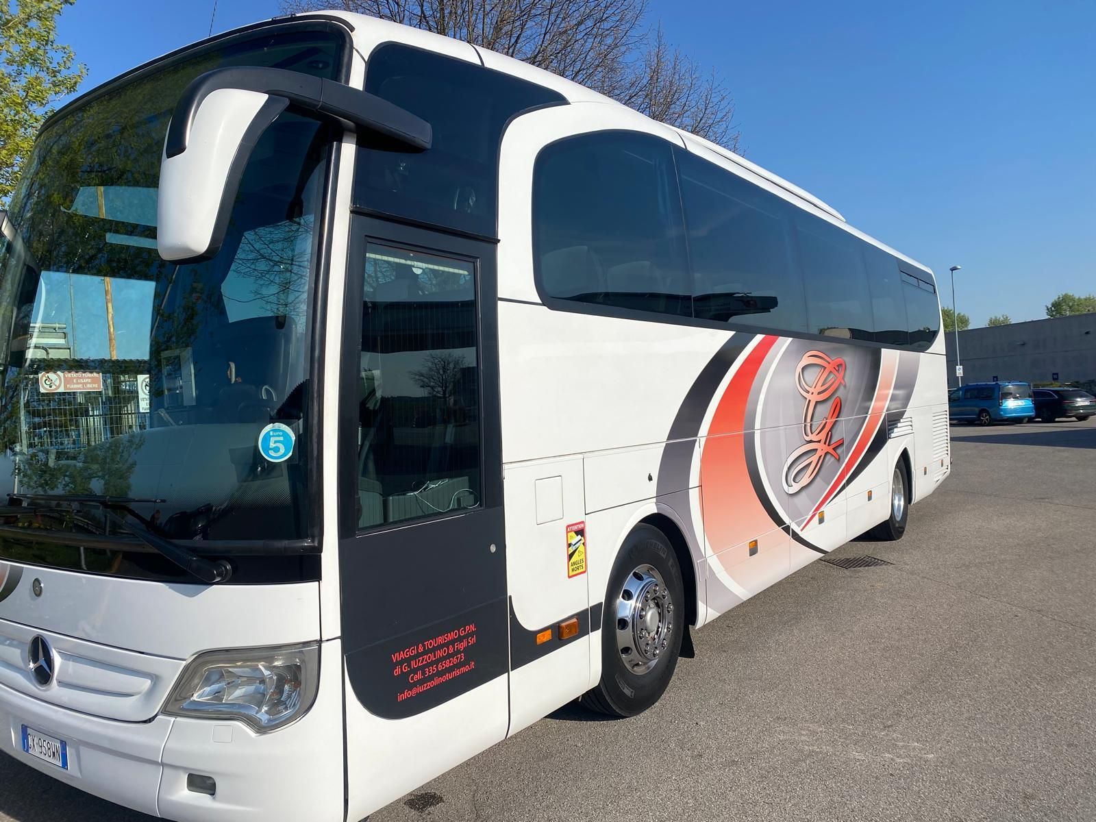Un autobus bianco è parcheggiato in un parcheggio.