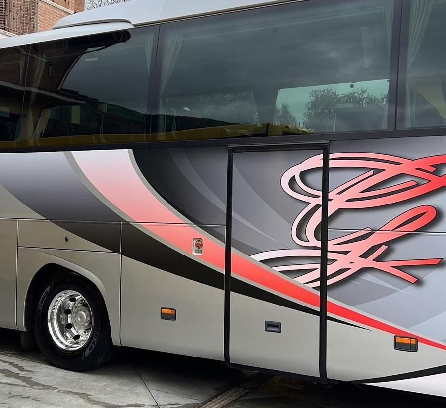 Un autobus argentato e rosso con la lettera e sul lato
