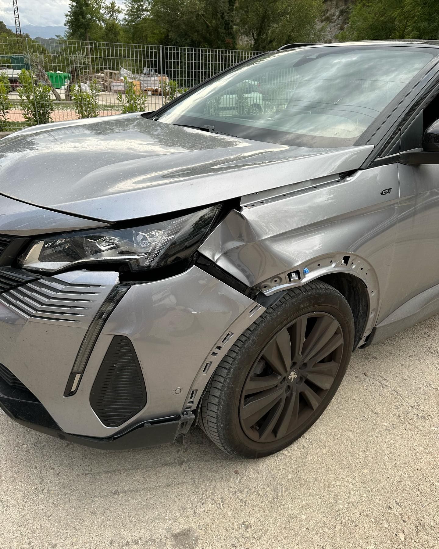SUV Peugeot argentato danneggiato su strada, visibile la collisione frontale.