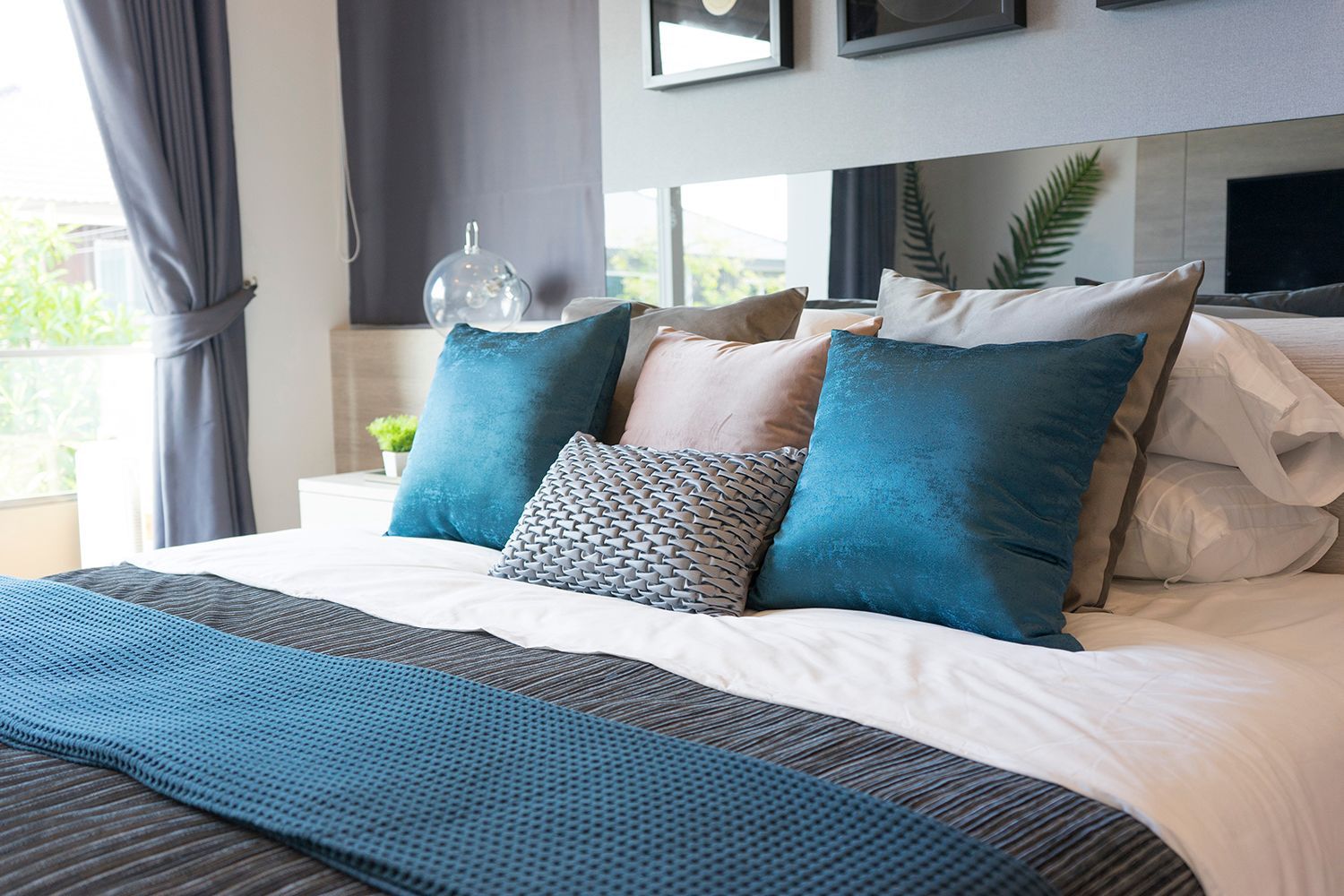 Luxury set of blue and gray pillows on bed.