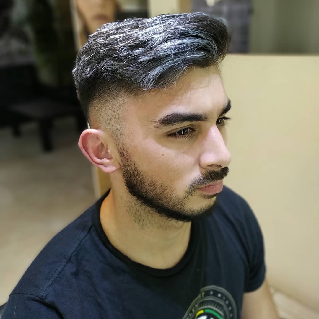 Un hombre con el pelo corto y descolorido y barba bien cuidada