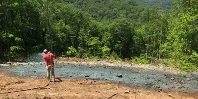 Man Watering An Empty Lot — Hendersonville, NC — Gravely Hydroseeding & Excavating