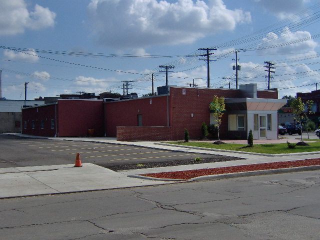 A red brick building sits on the corner of a street