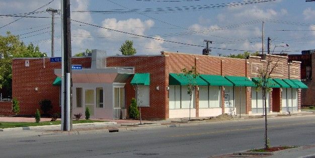 A row of small brick buildings with green awnings