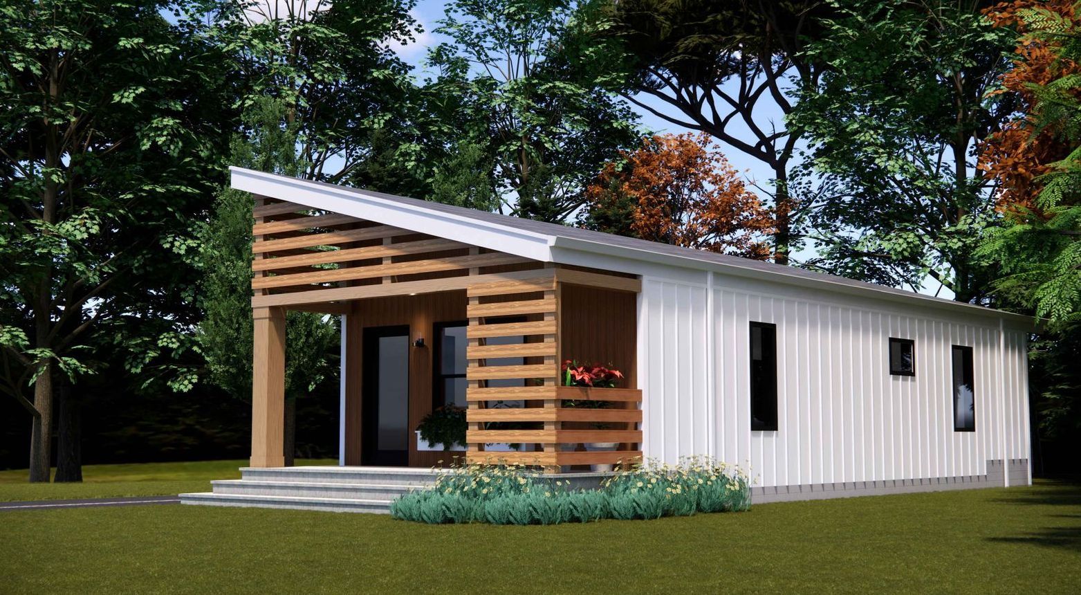 A small white house with a wooden porch is surrounded by trees.