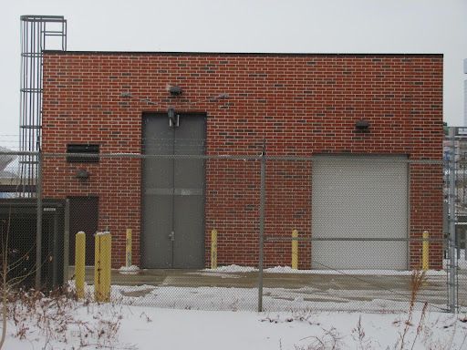 A brick building with a garage door and a fence around it