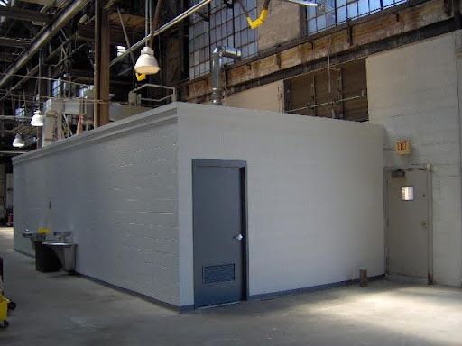 A large room with a door and a sink in a building.