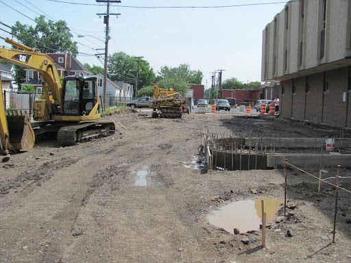 A construction site with a yellow cat excavator in the middle
