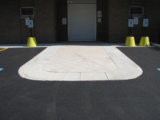 A parking lot with a ramp and a brick building in the background